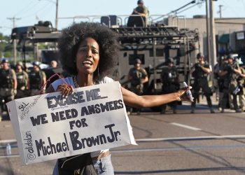 A protester shouts as she moves away from a line of riot police in Ferguson, Mo. on Wednesday, Aug. 13, 2014. On Saturday, Aug. 9, 2014, a white police officer fatally shot Michael Brown, an unarmed black teenager, in the St. Louis suburb. (AP Photo/St. Louis Post-Dispatch, J.B. Forbes)