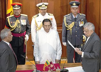 Ranil Wickremesinghe, right, takes oath as Sri Lankaís prime minister in front Sri Lankaís president Maithripala Sirisena, center, in Colombo, Sri Lanka, Friday, Aug. 21, 2015. Wickremesinghe's victory in Monday's election thwarted a political comeback bid by the country's former strongman president, Mahinda Rajapaksa, seven months after he lost his presidential re-election bid. (AP Photo/Gemunu Amarasinghe)