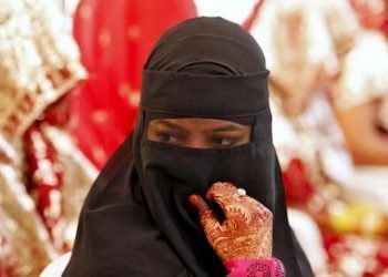 A veiled Muslim bride waits for the start of a mass marriage ceremony in Ahmedabad, India, October 11, 2015. A total of 65 Muslim couples from various parts of Ahmedabad on Sunday took wedding vows during the mass marriage ceremony organised by a Muslim voluntary organisation, organisers said. REUTERS/Amit Dave