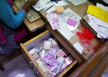 A bank employee counts discontinued currency notes while working at a currency exchange counter at a bank in Gauhati, India, Friday, Nov. 11, 2016. People queued up outside banks for the second day to exchange currency notes after Indian Prime Minister Narendra Modi, delivering one of India's biggest-ever economic upsets, declared that the bulk of Indian currency notes no longer held any value and asked anyone holding those bills to take them to banks to deposit or exchange them. (AP Photo/ Anupam Nath)