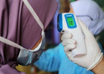 A nurse checks the temperature of a visitor as part of the coronavirus screening procedure at a hospital in Kuala Lumpur, Malaysia, February 3, 2020. REUTERS/Lim Huey Teng