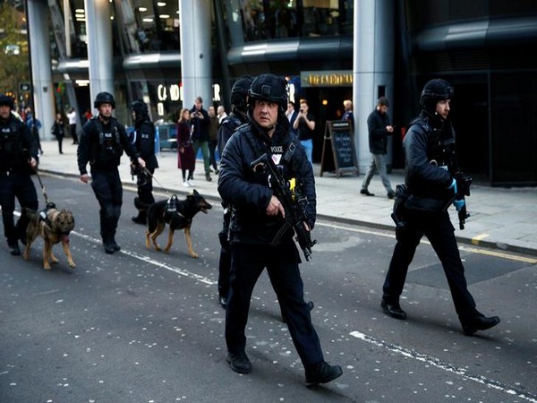 Police officers with sniffer dogs walk in the City, near the site of an incident at London Bridge in London, Britain, November 29, 2019. REUTERS/Peter Nicholls