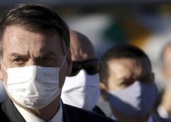 Brazil's President Jair Bolsonaro arrives for a flag raising ceremony outside Alvorada palace, the presidential residence in Brasilia, Brazil, Tuesday, May 12, 2020. The morning ceremony flew Brazil's flag at half mast to mourn those who have died from the new coronavirus. (AP Photo/Eraldo Peres)