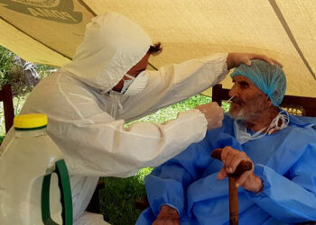 A paramedic wearing protective gear takes a nasal swab of 103 year-old Abdul Alim, to be tested for the coronavirus disease (COVID-19), at the Aga Khan Health Services Emergency Response Centre in Booni, Chitral, Pakistan in this undated photograph provided to Reuters. Suhail Aziz/Handout via REUTERS ATTENTION EDITORS - THIS PICTURE WAS PROVIDED BY A THIRD PARTY.
