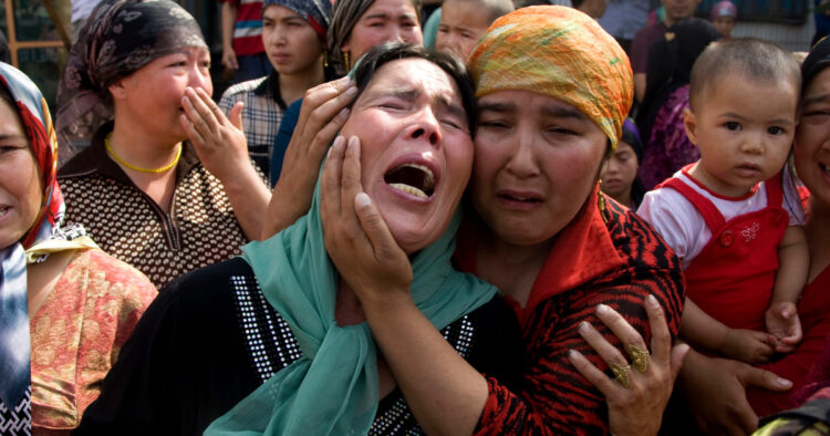 Uigher  women grieving for their men who they claim were taken away by the Chinese authorities after Sunday's protest in Urumqi, China, Tuesday, July 7 , 2009. (AP Photo/Ng Han Guan)