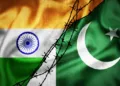 Grunge flags of India and Pakistan divided by barb wire illustration, concept of tense relations between India and Pakistan